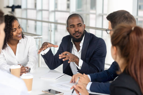 black millennial boss leading corporate team during briefing in boardroom - liderança imagens e fotografias de stock
