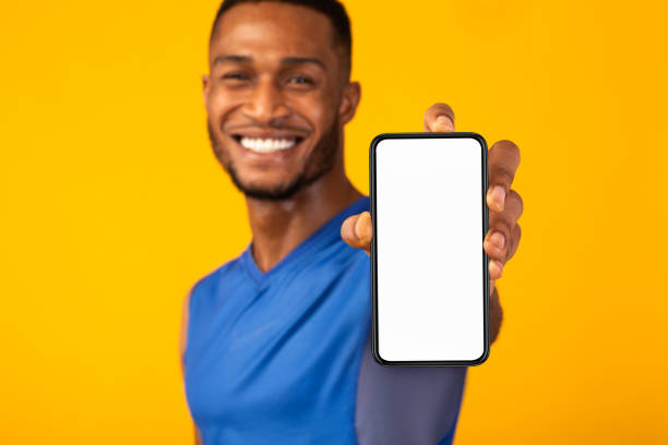 schwarze millennial gman zeigt weißes leeres telefon - handy mockup coach stock-fotos und bilder