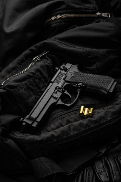 Black modern pistol on a dark background. A short-barreled weapon for concealed carry. Armament of the police, army and special units. stock photo
