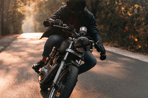 Handsome biker with classic style black motorcycle. Cafe racer
