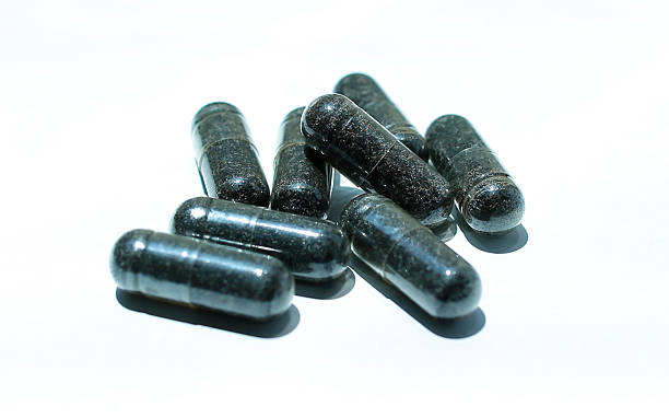 Black pills on a white background stock photo