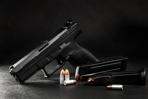 black pistol and cartridges on a dark back stock photo