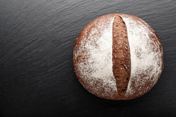 black round homemade bread on a black background. stock photo
