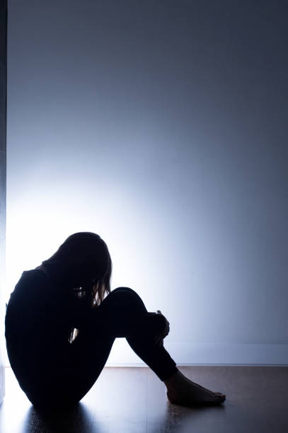 Black silhouette of teenage girl Black silhouette of teenage girl sitting on floor drug abuse stock pictures, royalty-free photos & images