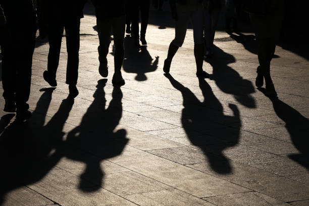 Black silhouettes and shadows of people on the street Crowd walking down on sidewalk, concept of pedestrians, crime, society, city life gang stock pictures, royalty-free photos & images