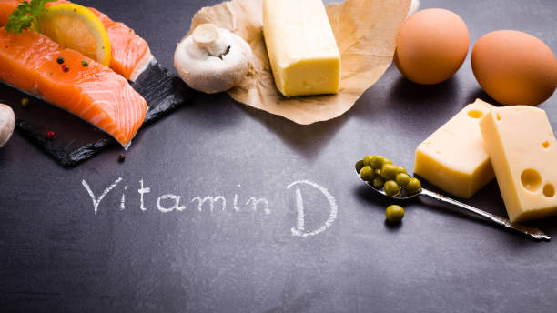 Black slate table with product rich in vitamin D and omega 3. Written word vitamin D by white chalk. stock photo