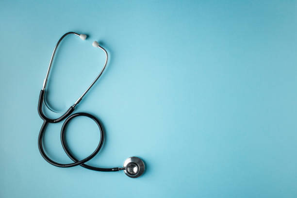 black stethoscope on blue background - medicine imagens e fotografias de stock