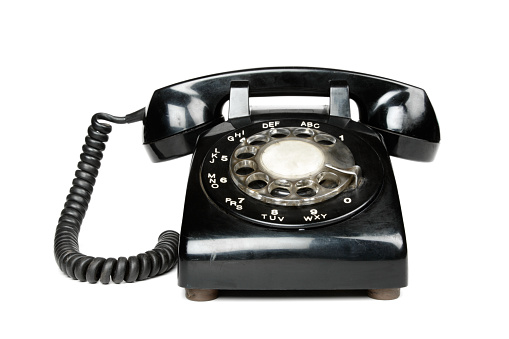 A black rotary telephone, isolated on a white background.