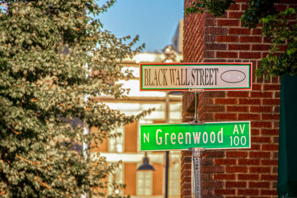 Black Wall Street and N Greenwood Avenue street signs - closeup - in Tulsa Oklahoma with bokeh background stock photo