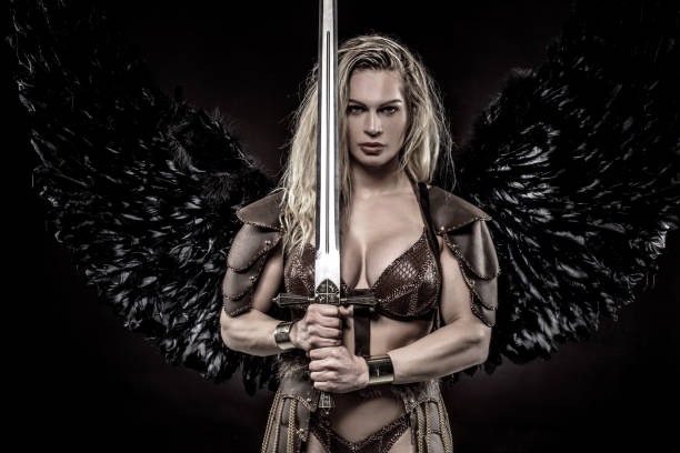 Black Wing Viking Valkyrie Female Black Wing Viking Valkyrie young blond female wielding a sword in a studio shot armour of god stock pictures, royalty-free photos & images