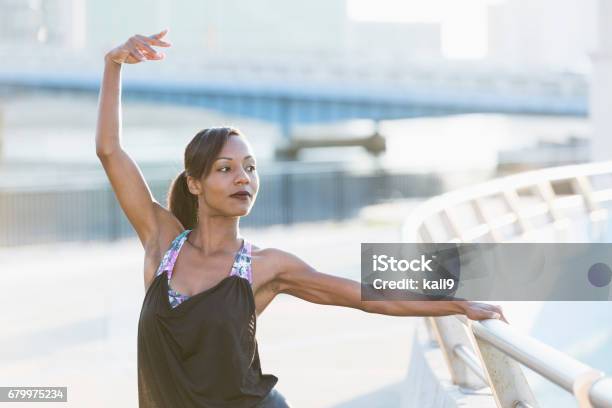 Black woman exercising outdoors, doing yoga