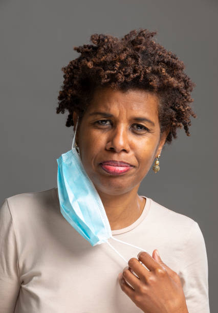 Black woman taking off a face mask stock photo
