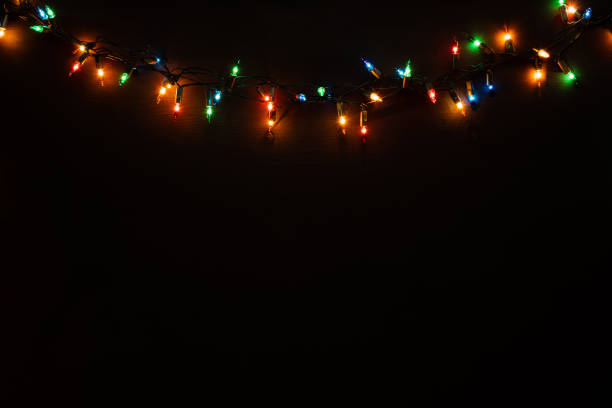 Black wooden background with christmas lights on the rustic wooden background. Flat lay. stock photo