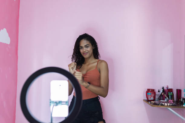 black young woman filming herself dancing at home to share on social media - tiktok stockfoto's en -beelden