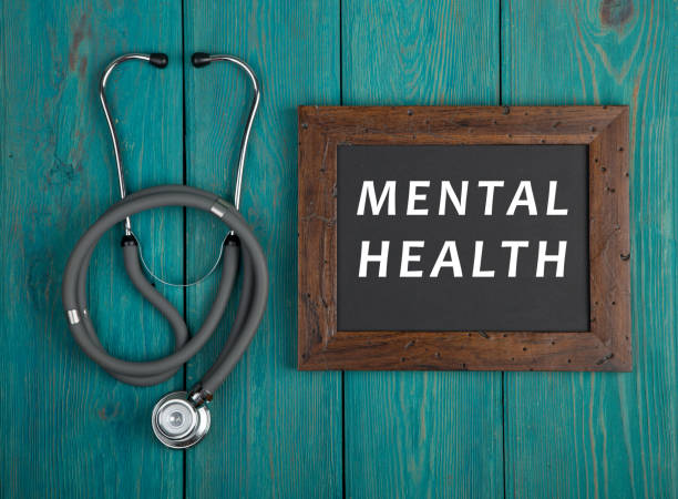 Blackboard with text "Mental health" and stethoscope on blue wooden background stock photo