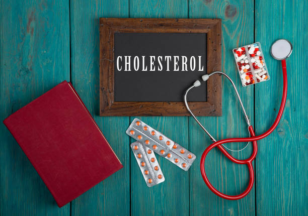 Blackboard with word "Cholesterol", stethoscope, book, pills stock photo