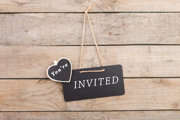 Blackboards with text "You're invited" on wooden background stock photo