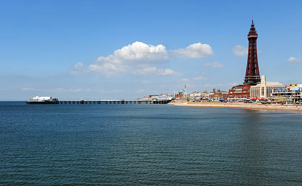 Blackpool North Pier and Tower The iconic Blackpool Tower and north pier on a bright sunny summers day with the Irish sea looking almost Mediterranean and as calm as a mill pond. north pier stock pictures, royalty-free photos & images