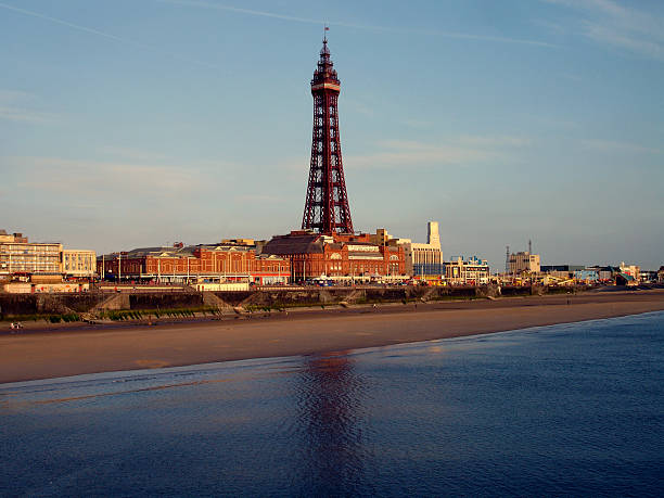 Blackpool Tower, Beach and Sea at Sunset Blackpool, England iconic landmark of the Blackpool Tower with beach and sea at sunset blackpool tower stock pictures, royalty-free photos & images