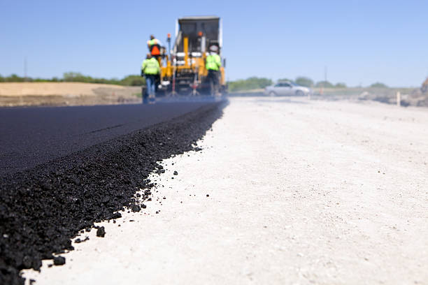 blacktop paving road with paver and dump truck - asfalt stockfoto's en -beelden