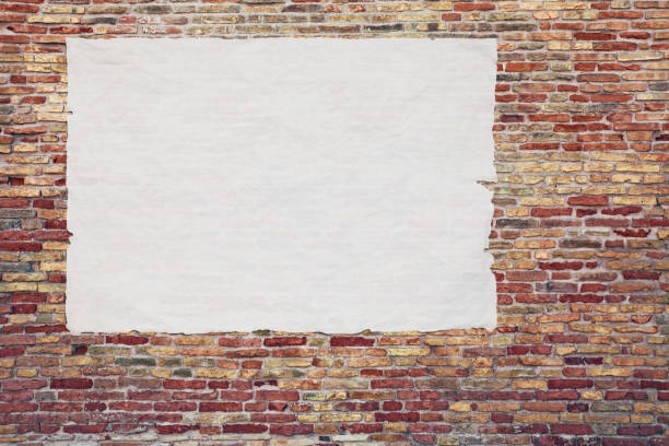 blank advertising poster glued to the brick wall stock photo