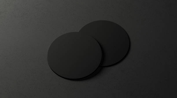 Blank black two beer coasters mockup set on dark surface Blank black two beer coasters mockup set on dark surface, 3d rendering. Empty cardboard pad for glass mock up. Clear display for beer can template. Protect cork pedestal. coaster stock pictures, royalty-free photos & images