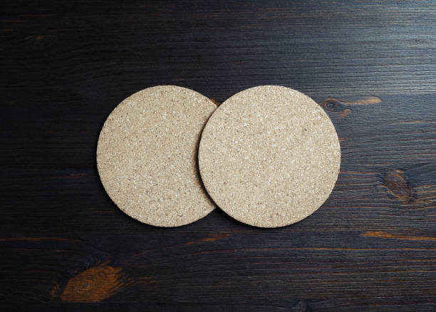 Blank cork coasters Two blank cork beer coasters on wood table background. Flat lay. coaster stock pictures, royalty-free photos & images