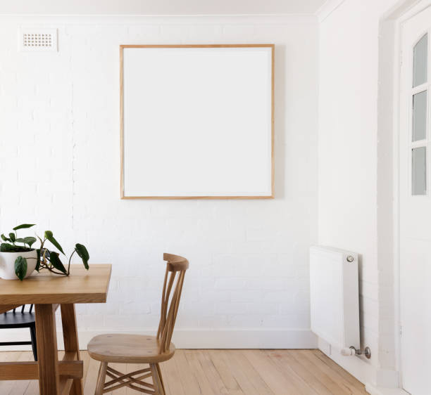 Blank framed print on white wall in danish styled interior dining room stock photo