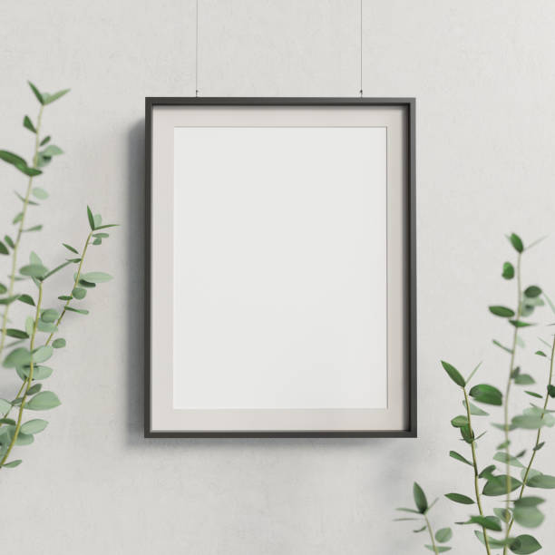 Blank mockup poster hanging against concrete wall decorated by plant branches. 3D render. stock photo