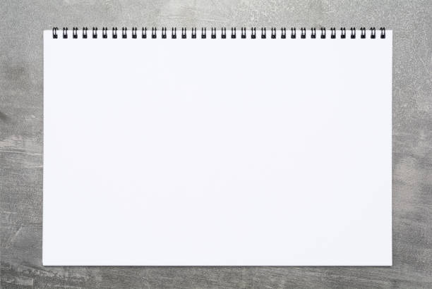 Blank page of a sketchbook over gray surface Blank page of a sketchbook over gray surface sketch pad stock pictures, royalty-free photos & images