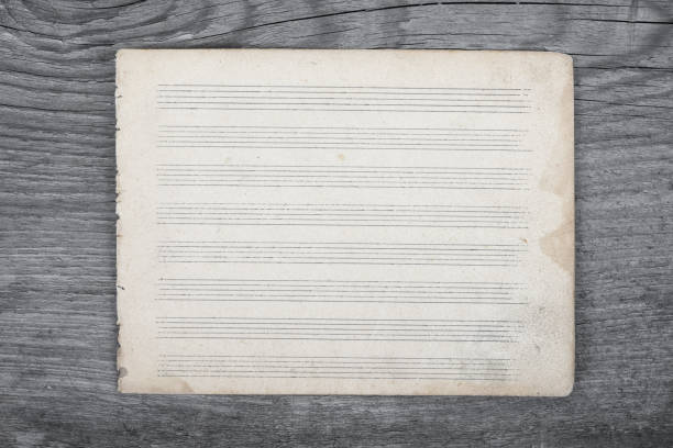 Blank sheet music on wooden rustic background. Top view. stock photo