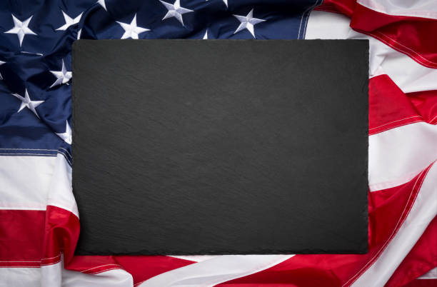 Blank slate board over American flag as a concept for US national celebrations Blank slate board over American flag as a concept for US national celebrations memorial day background stock pictures, royalty-free photos & images