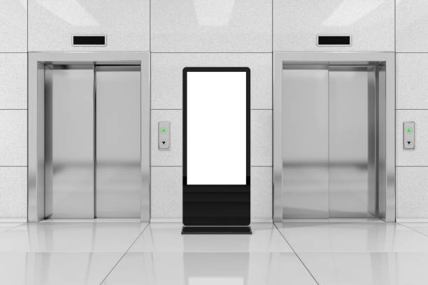 Blank Trade Show LCD Screen Stand as Template for Your Design near Modern Elevator or Lift with Metal Doors in Office Building. 3d Rendering stock photo