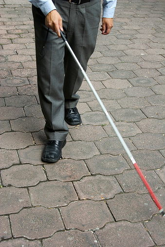 blind-man-walking-with-a-red-and-white-cane-picture-id172164749