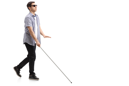 blind-young-man-with-a-cane-walking-picture-id953478548