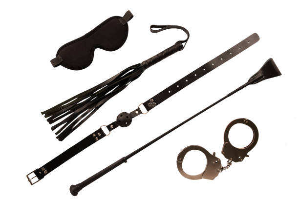 Blindfold mask, riding crop and a ball gag, isolated stock photo