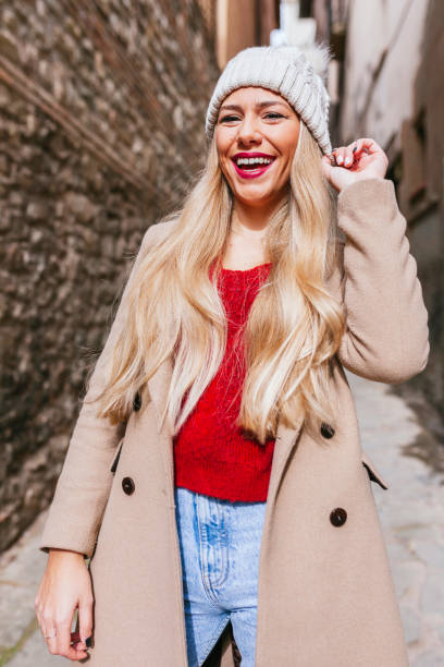 Blond latin woman in winter clothes posing in the street stock photo