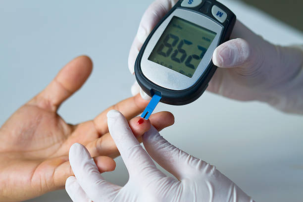 blood glucose meter on finger Hand of doctor and white glove show blood glucose meter, the blood sugar value is measured on a finger hyperglycemia stock pictures, royalty-free photos & images