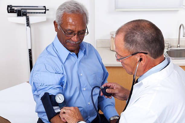Blood Pressure Measurement XXXL.  Patient getting his blood pressure taken in a doctor's office. gchutka stock pictures, royalty-free photos & images