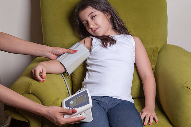 blood pressure of small beautiful middle eastern girl Doctor checking blood pressure of small beautiful middle eastern girl sitting on green chair and feeling bad. hot arabic girl stock pictures, royalty-free photos & images
