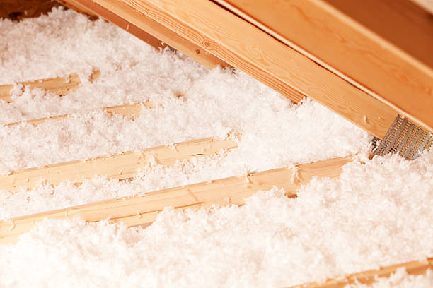 Blown Attic Insulation at Eave Area "Blown insulation between attic trusses, the angle to the right is the eave which extends beyond the house walls." attic stock pictures, royalty-free photos & images
