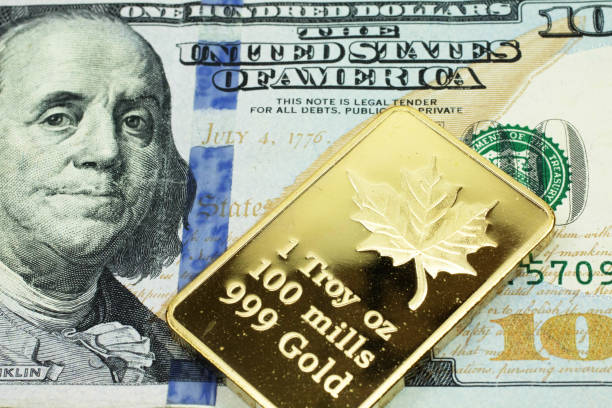 A blue American one hundred dollar bill with a gold bar in macro stock photo