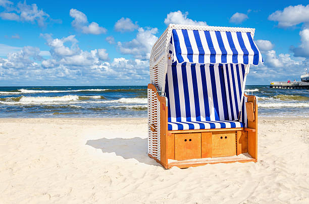 Blue and white wicker chair on sandy beach stock photo