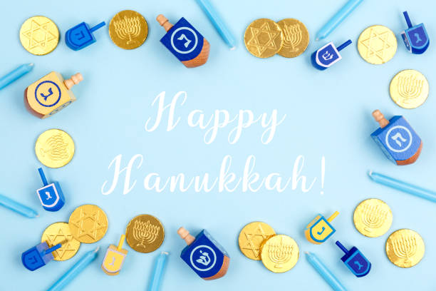 fondo azul con dreidels multicolores, velas menora y monedas de chocolate con happy hanukkah. concepto de vacaciones hanukkah y judaico. - happy hanukkah fotografías e imágenes de stock