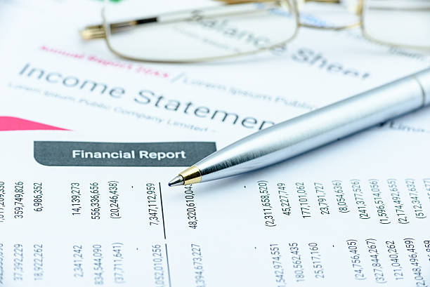 Blue ballpoint pen on a quarterly corporate financial report. Blue ballpoint pen on a quarterly corporate financial report on a table waiting for the financial and investment analyst to analyse before public disclosure. Financial investment analysis concept. bank statement stock pictures, royalty-free photos & images