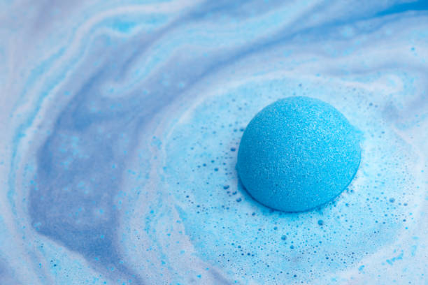 Blue bath bomb foaming in water Blue bath bomb foaming in water, close up view chemical reaction stock pictures, royalty-free photos & images