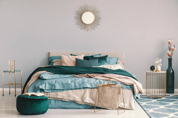 bleu, beige et vert émeraude literie sur lit king size dans l’intérieur de la chambre contemporaine avec des accents dorés - chambre bleu et vert photos et images de collection