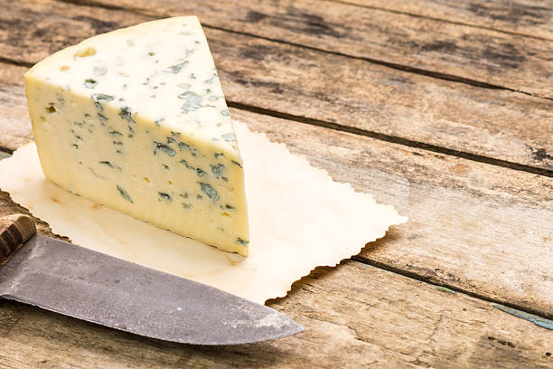 Blue cheese background with copyspace. Roquefort cheese with old knife