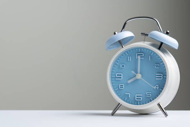 Blue classic alarm clock at eight o'clock stock photo