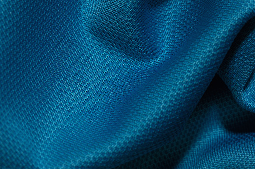 Blue crumpled fabric background. Abstract texture, empty template. Selective focus.